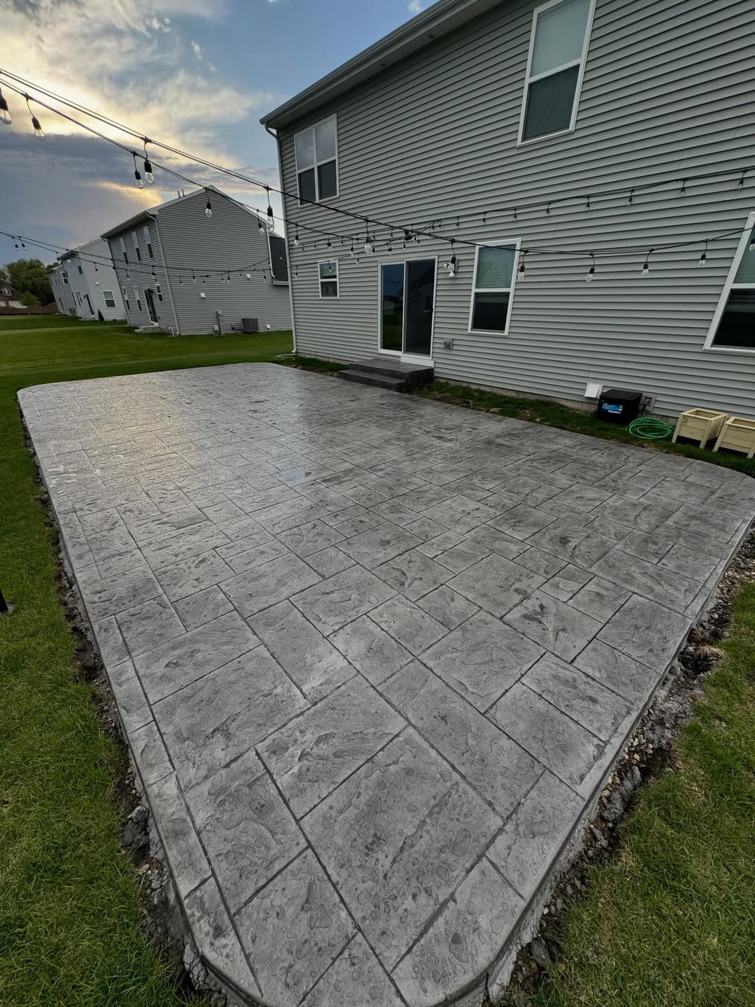 Representative example of a stamped concrete patio behind a home